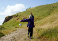estrella/x holding a disco ball on a hillside