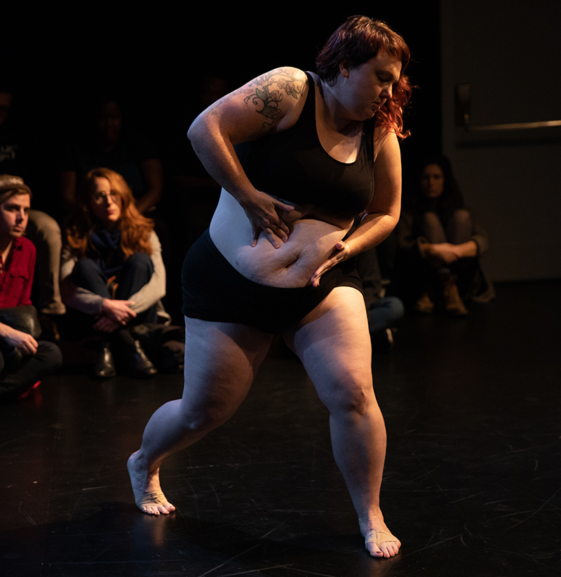 KT in performance grabbing her belly.