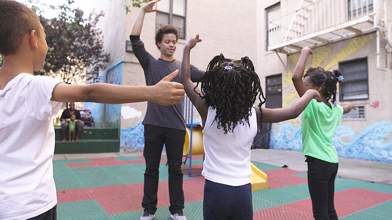 Melendez teaches port de bras to kids outside.