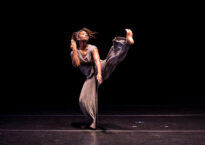 Melanie does a kick forward onstage.