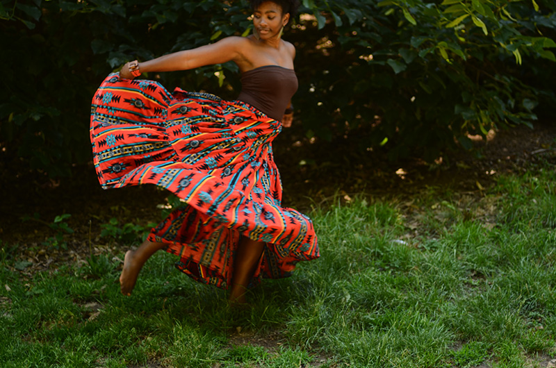 Melanie runs through grass with a big skirt.