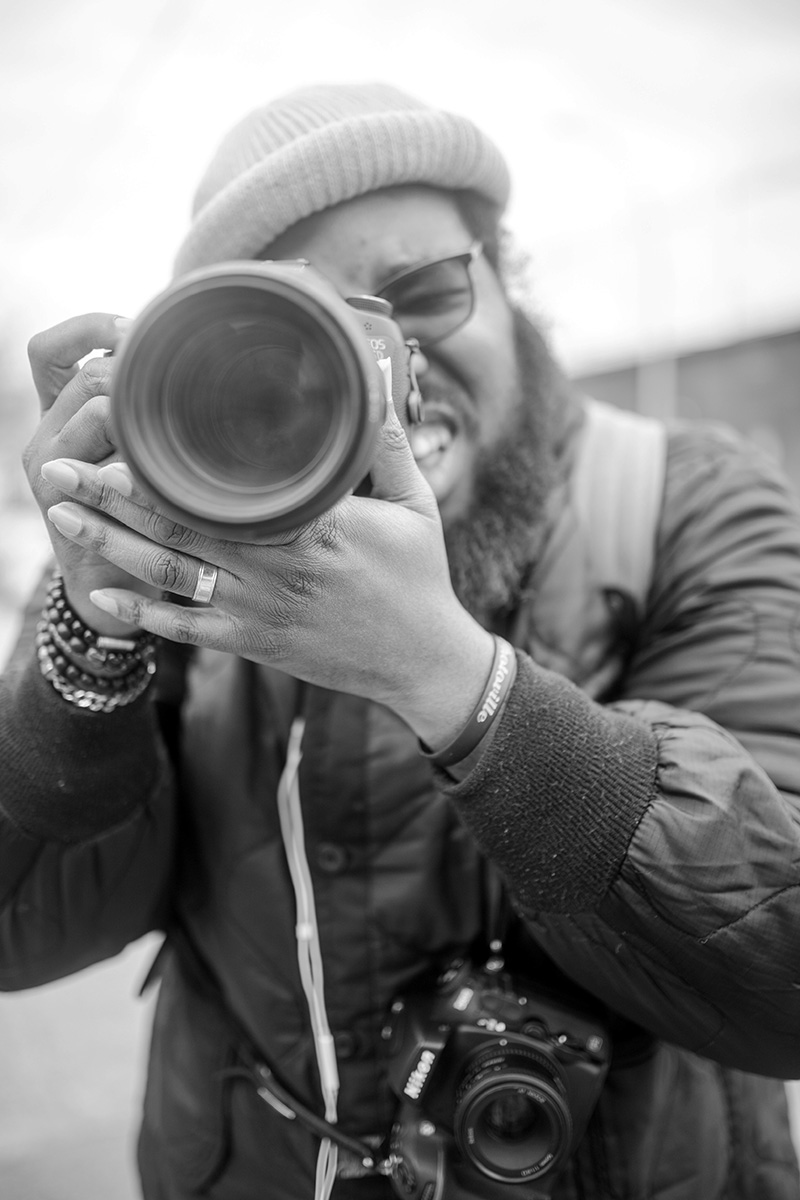 Steven is behind a large lens. The photo is in black and white.