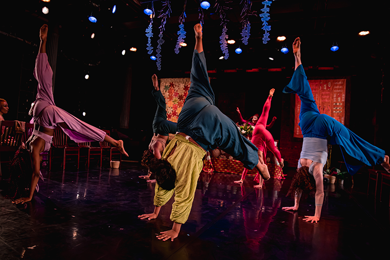 Five dancers do a handstand onstage
